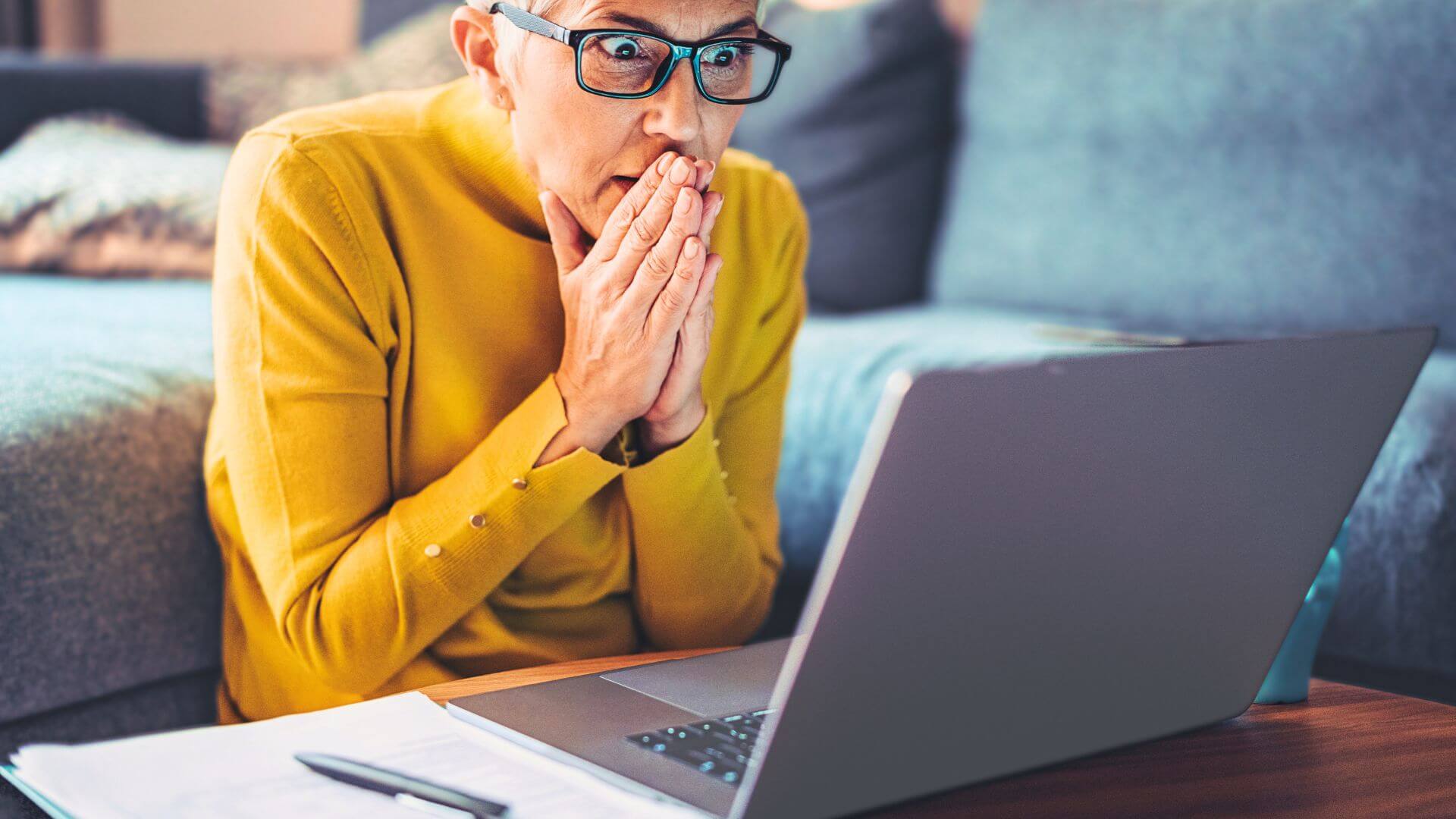 Frau sitzt erschrocken vor ihrem Computer